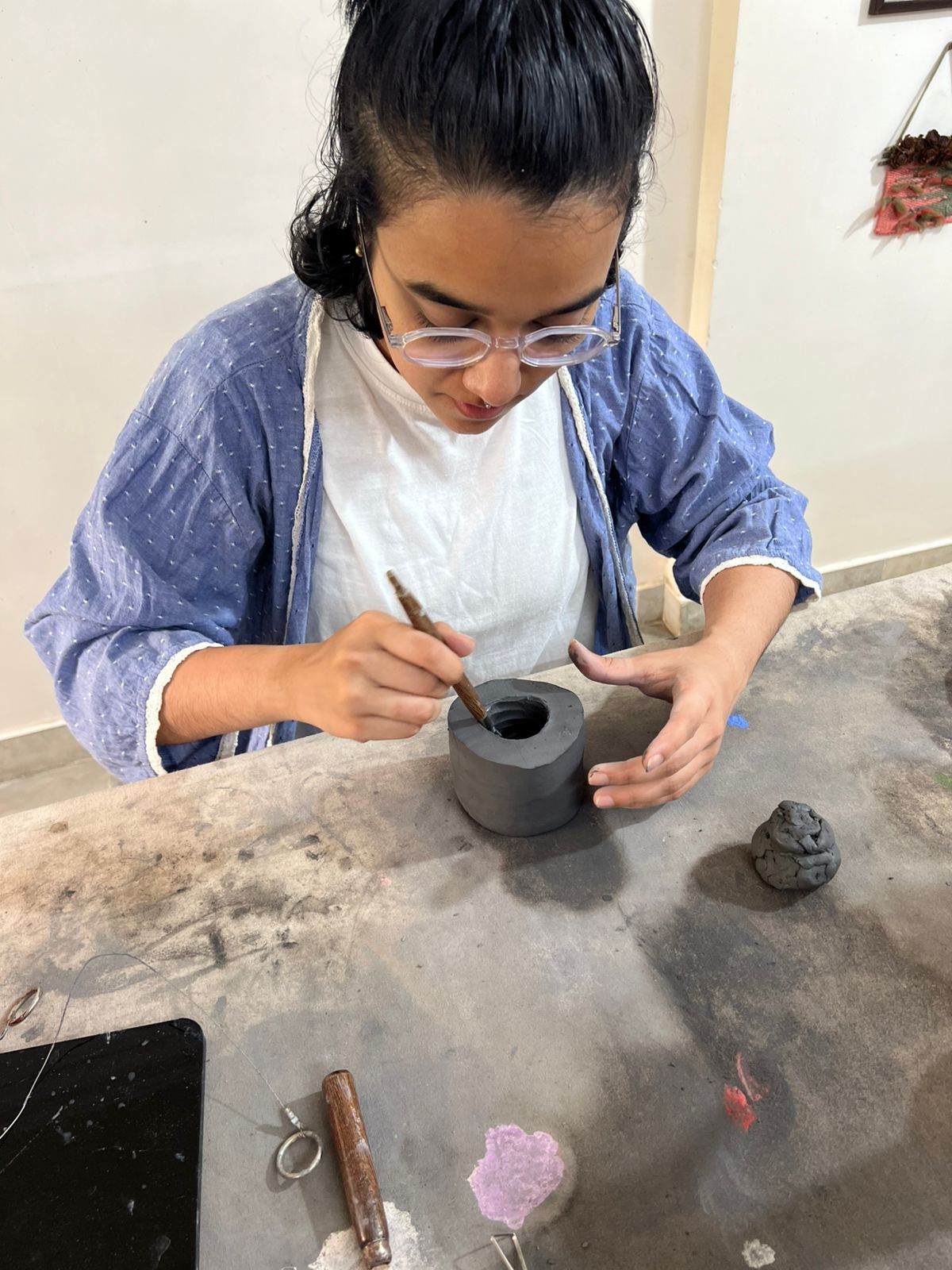 Participant carefully carving and shaping a solid clay piece to create Japanese-style Kurinuki pottery in Mumbai.